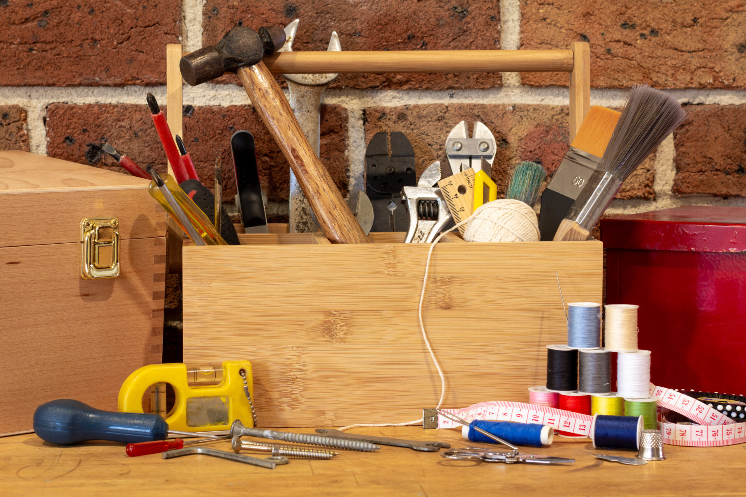 A tool box surrounded by repair tools on bench in cafe used as a repair center, to repair household items to reduce waste and support a sustainable lifestyle.
